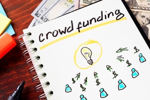 Notebook with crowd funding sign on a table.